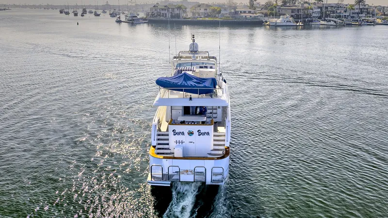 Bora Bora Yacht Photos Pics Luxury yacht cruising on calm waters, Paragon mk 2009 model, scenic coastal backdrop.