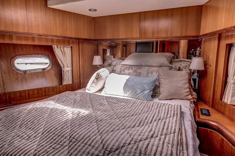 Bora Bora Yacht Photos Pics Luxurious cabin interior of 2009 Paragon mk yacht with cozy bedding and wooden paneling.