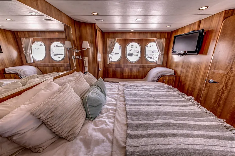 Bora Bora Yacht Photos Pics Luxurious yacht bedroom with wood paneling, porthole windows, and a cozy bed, Paragon mk 2009.