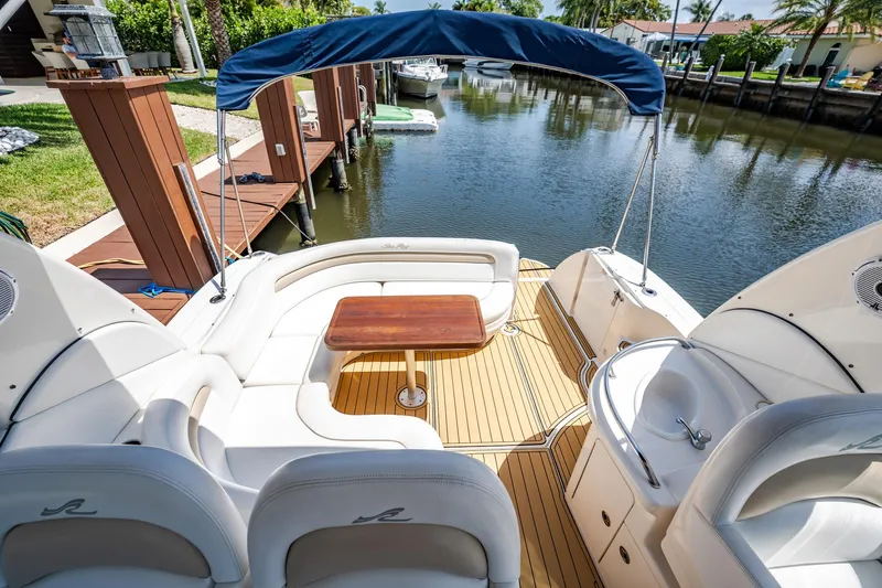 Bella Vita Yacht Photos Pics 2008 Sea Ray 340 Sundancer boat with seating area, wooden table, and canopy by a dock.