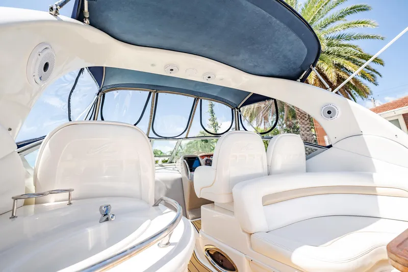 Bella Vita Yacht Photos Pics 2008 Sea Ray 340 Sundancer interior with white seating and blue canopy, palm tree in background.