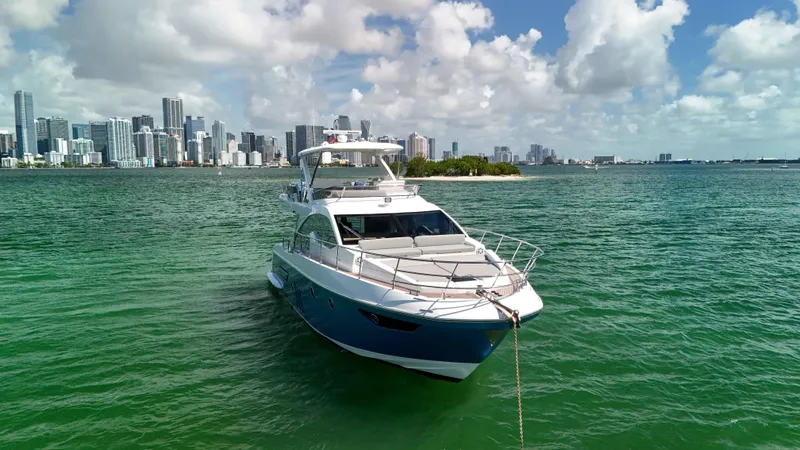 Fortunato Yacht Photos Pics Azimut 50 Flybridge 2016 yacht anchored near city skyline, clear skies, and green waters.