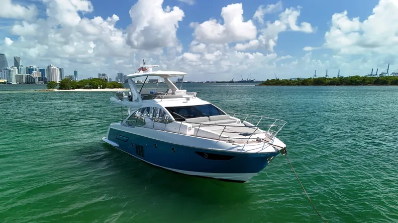 Fortunato Yacht Photos Pics 2016 Azimut 50 Flybridge yacht on turquoise water with city skyline in background.