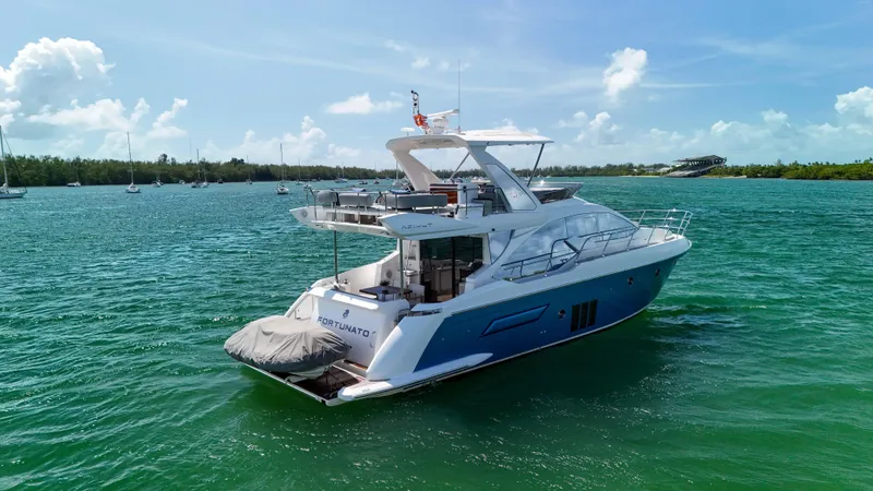 Fortunato Yacht Photos Pics 2016 Azimut 50 Flybridge yacht on serene blue waters under a clear sky.