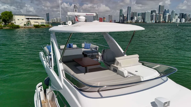 Fortunato Yacht Photos Pics 2016 Azimut 50 Flybridge yacht cruising near city skyline, featuring spacious deck and modern design.