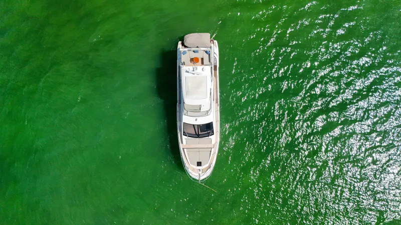 Fortunato Yacht Photos Pics Aerial view of 2016 Azimut 50 Flybridge yacht on vibrant green water.