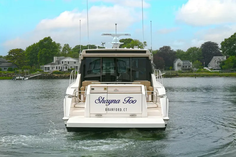  Yacht Photos Pics 2015 Tiara Yachts C44 Coupe on water, rear view, with scenic background.