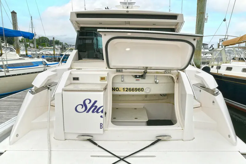  Yacht Photos Pics 2015 Tiara Yachts C44 Coupe at dock, open storage compartment visible.