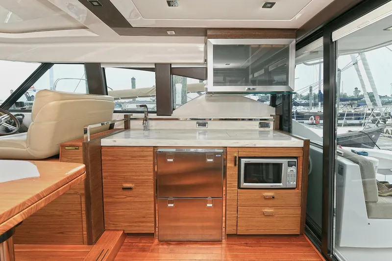  Yacht Photos Pics Interior of 2015 Tiara Yachts C44 Coupe, featuring modern kitchen with wood cabinetry and appliances.