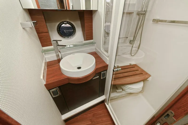  Yacht Photos Pics Luxurious bathroom in 2015 Tiara Yachts C44 Coupe with modern fixtures and wood accents.