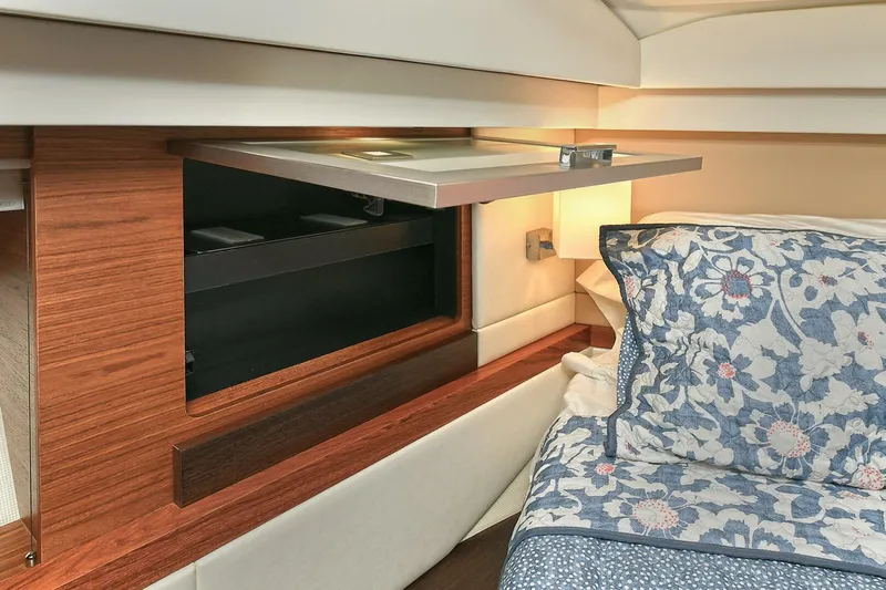  Yacht Photos Pics Interior of 2015 Tiara Yachts C44 Coupe with floral bedding and wooden storage compartment.