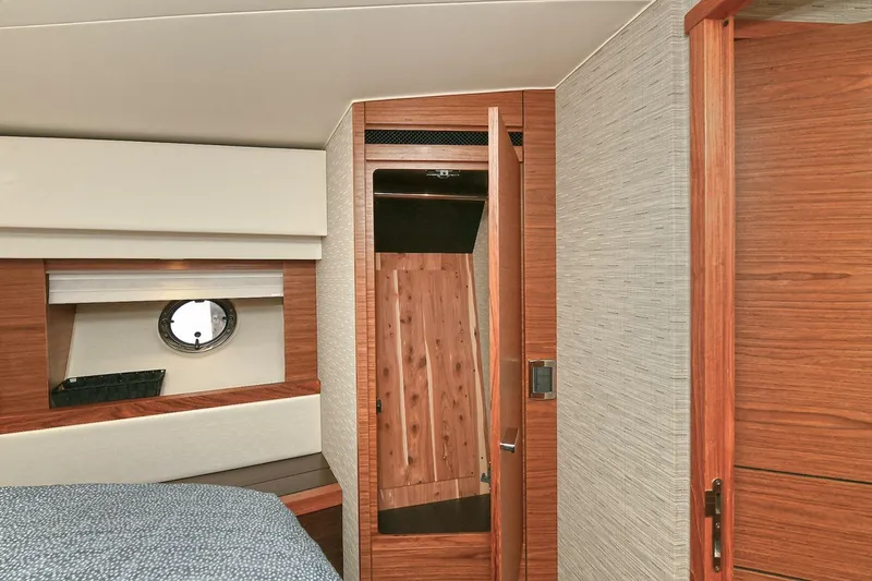  Yacht Photos Pics Interior of 2015 Tiara Yachts C44 Coupe, featuring wood finishes and a porthole window.