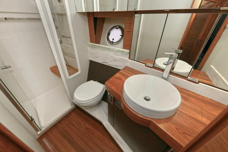  Yacht Photos Pics Luxurious bathroom in 2015 Tiara Yachts C44 Coupe with modern fixtures and wood accents.