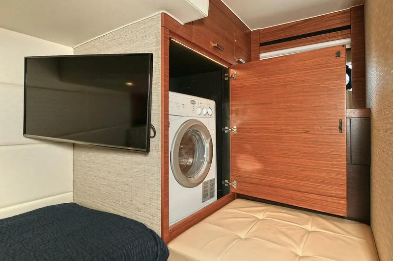  Yacht Photos Pics 2015 Tiara Yachts C44 Coupe interior with TV, washer, and wooden cabinetry.