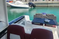 Interior view of 2022 Karnic CS 700HT boat with seating and table, docked in marina.
