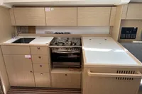 Modern kitchen interior of 2024 Bavaria C38 yacht with stove, sink, and wooden cabinetry.