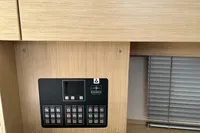 Control panel of 2024 Bavaria C38 yacht with wooden finish and blinds.