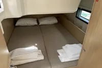 2024 Bavaria C38 yacht cabin with double bed, pillows, and folded towels.