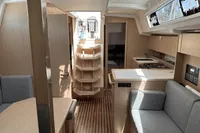 2024 Bavaria C38 yacht interior with modern kitchen, seating, and wooden finishes.