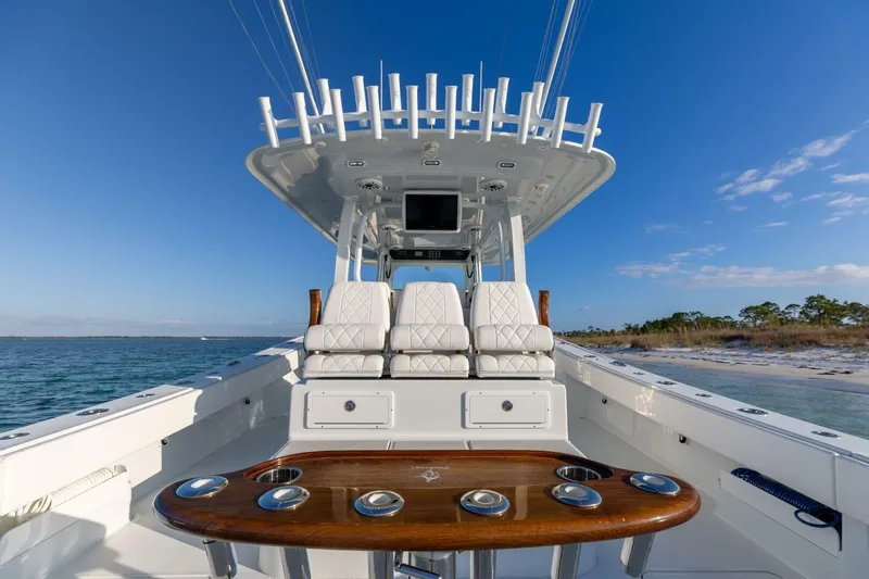Just Looking Yacht Photos Pics 2024 Freeman 47 boat interior with luxurious seating and fishing rod holders, ocean backdrop.