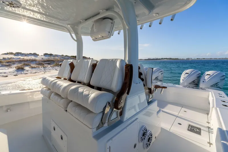 Just Looking Yacht Photos Pics 2024 Freeman 47 boat interior with luxurious seating and powerful engines, cruising near a sandy shoreline.