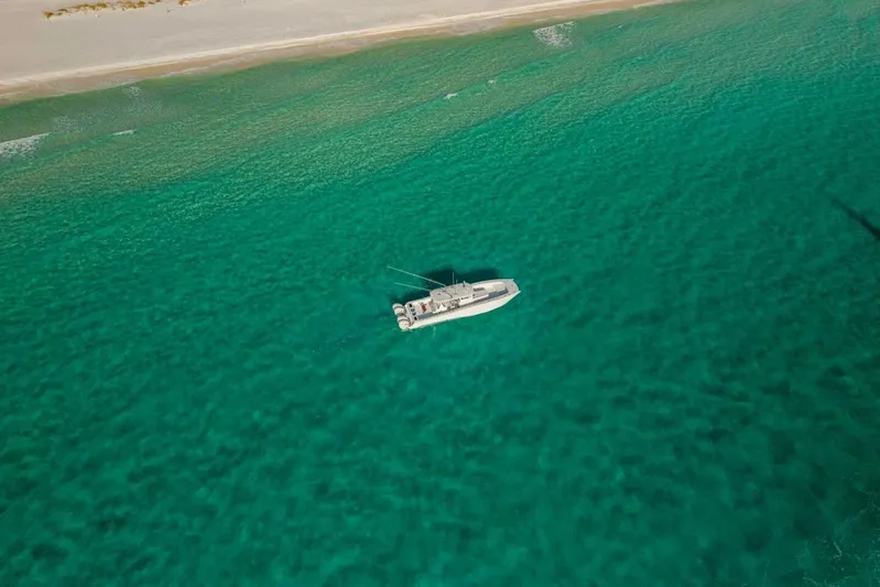 Just Looking Yacht Photos Pics Aerial view of 2024 Freeman 47 boat on turquoise ocean near sandy beach.