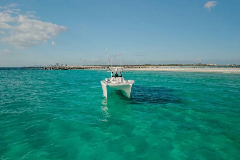 Just Looking Yacht Photos Pics 2024 Freeman 47 boat on turquoise water near sandy shoreline under blue sky.