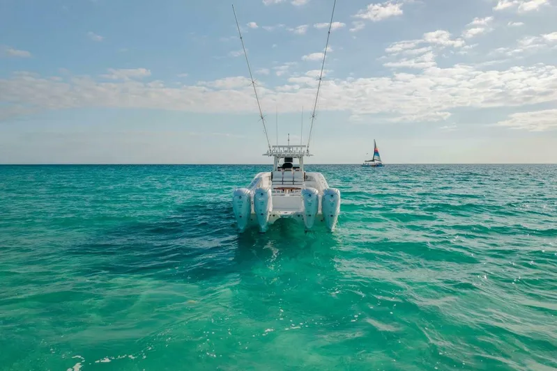Just Looking Yacht Photos Pics 2024 Freeman 47 boat on turquoise ocean with sailboat in distance under blue sky.