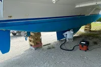 Leopard 45 catamaran on blocks, undergoing maintenance, with vacuum cleaner nearby.