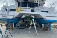 2020 Leopard 45 catamaran on land, undergoing maintenance with tools and ladders.