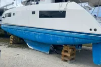 2020 Leopard 45 catamaran on dry dock, white hull with blue bottom, overcast sky.
