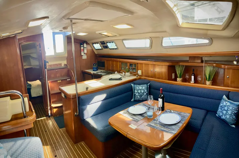 Light Seeker Yacht Photos Pics Interior of 2005 Hunter 41 AC sailboat with cozy dining area and elegant wood finish.