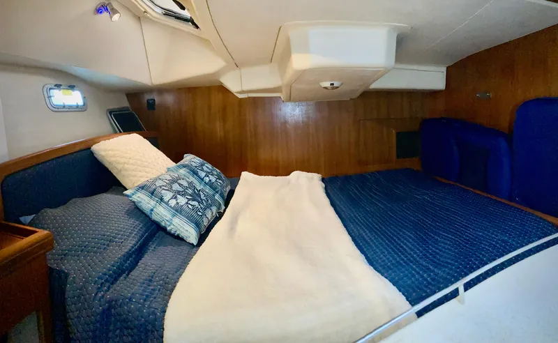 Light Seeker Yacht Photos Pics Cozy cabin interior of 2005 Hunter 41 AC sailboat with blue bedding and wooden paneling.