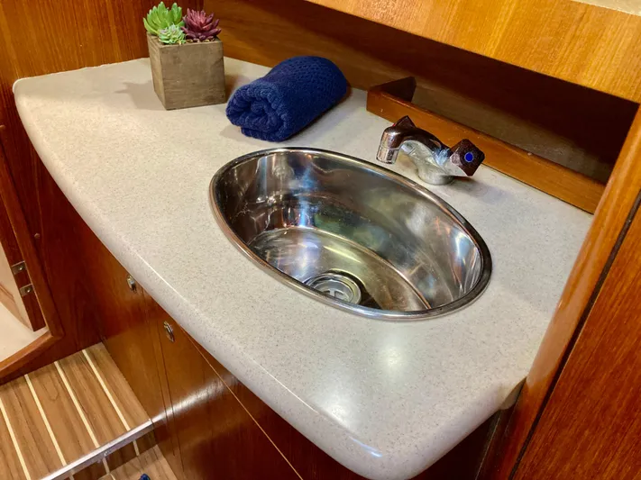 Light Seeker Yacht Photos Pics 2005 Hunter 41 AC yacht bathroom sink with faucet, countertop, and decorative plants.