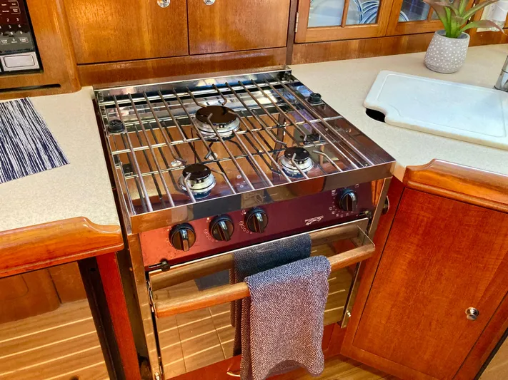 Light Seeker Yacht Photos Pics 2005 Hunter 41 AC yacht kitchen with stove, wooden cabinetry, and countertop plant.