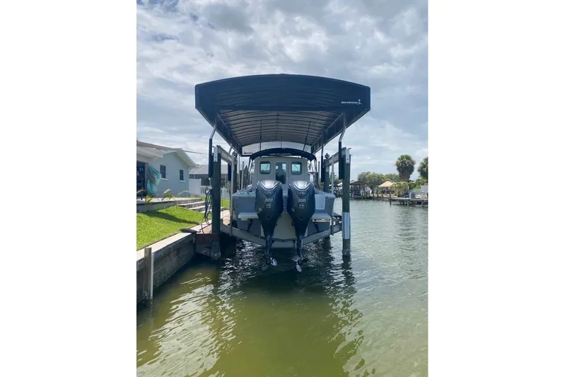  Yacht Photos Pics 2024 Parker 2820 XLD Sport Cabin boat docked under a covered lift.