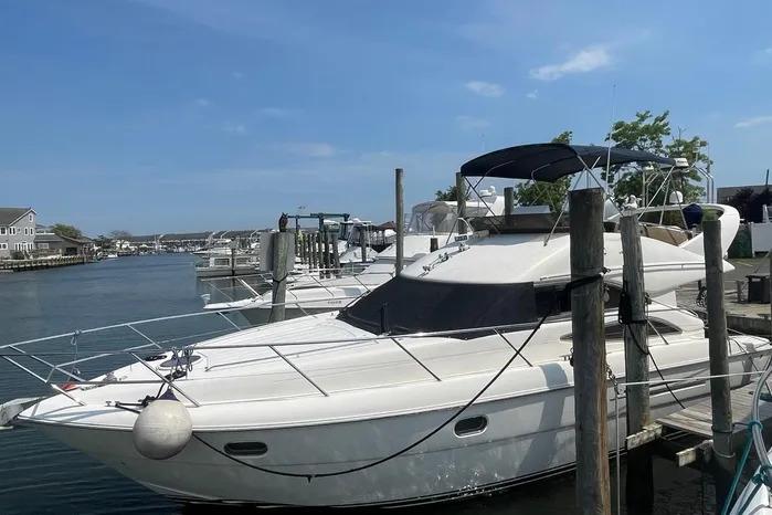 2001 Viking Princess Fly Bridge yacht docked, clear sky, waterfront view.
