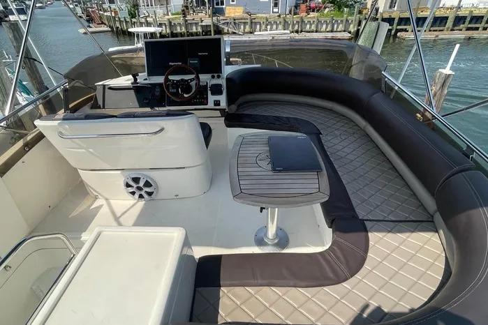 Luxurious 2001 Viking Princess yacht deck with seating, table, and helm, docked by the water.