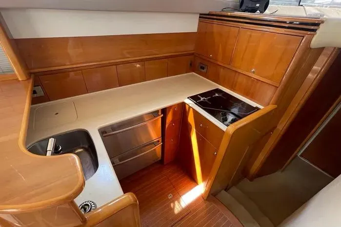  Yacht Photos Pics 2001 Viking Princess yacht kitchen with wood cabinetry, stainless steel appliances, and compact design.