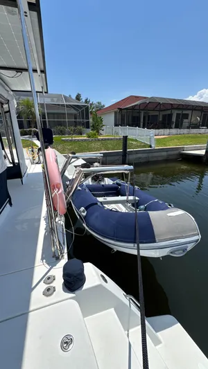 Aquamarine Yacht Photos Pics 2013 Lagoon 450 F catamaran docked with inflatable boat, sunny day.