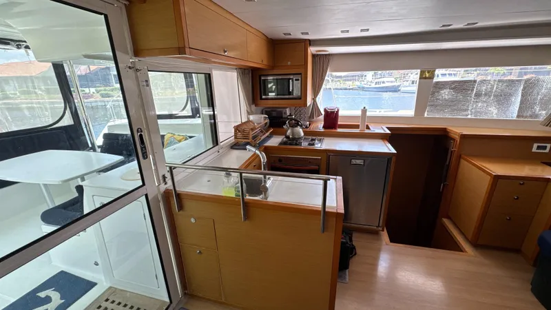 Aquamarine Yacht Photos Pics Interior of 2013 Lagoon 450 F yacht kitchen with modern amenities and wooden cabinetry.