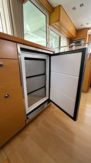 Aquamarine Yacht Photos Pics Open refrigerator in 2013 Lagoon 450 F yacht interior, showcasing modern design and wood cabinetry.