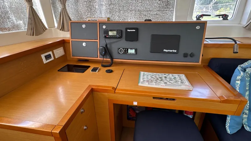 Aquamarine Yacht Photos Pics Navigation station inside 2013 Lagoon 450 F catamaran with Raymarine equipment and wooden finish.