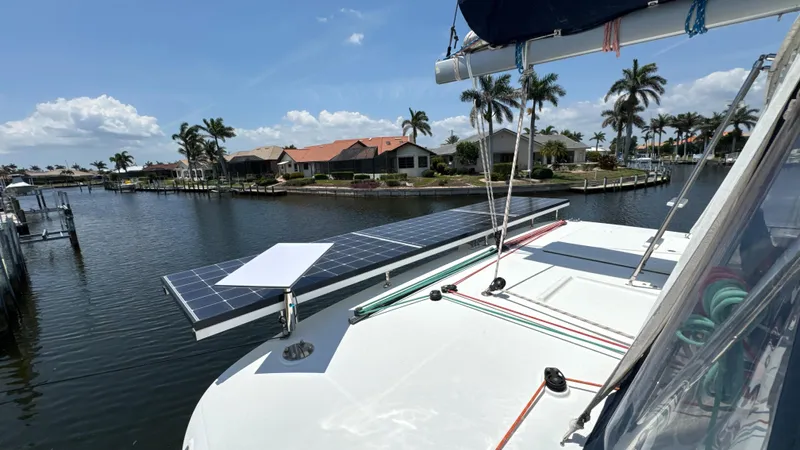 Aquamarine Yacht Photos Pics Lagoon 450 F catamaran with solar panels docked by waterfront homes, 2013 model.