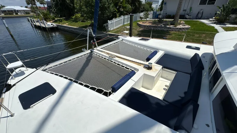 Aquamarine Yacht Photos Pics 2013 Lagoon 450 F catamaran with spacious deck and netting, docked by a canal.
