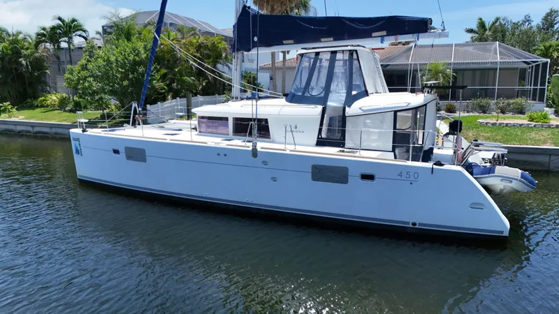 Aquamarine Yacht Photos Pics 2013 Lagoon 450 F catamaran docked in a serene canal setting.
