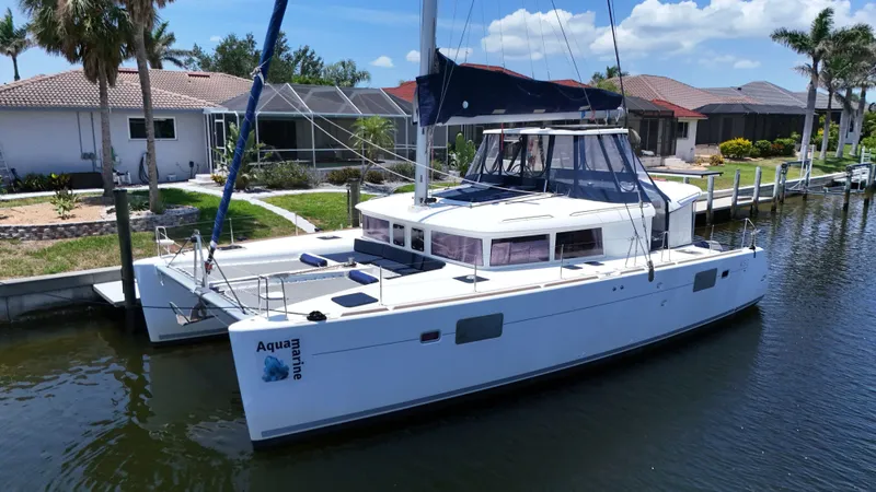 Aquamarine Yacht Photos Pics 2013 Lagoon 450 F catamaran docked in a sunny residential canal.