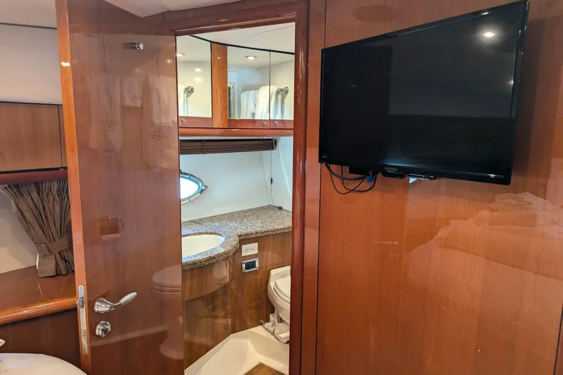  Yacht Photos Pics Luxurious bathroom interior of 2006 Sunseeker Predator 68 yacht with TV and wooden finish.