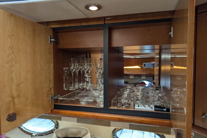  Yacht Photos Pics Luxurious glassware cabinet inside 2006 Sunseeker Predator 68 yacht, featuring elegant wood finish.