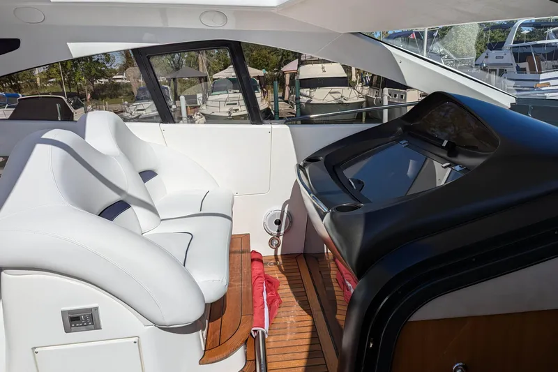  Yacht Photos Pics Luxurious interior of 2006 Sunseeker Predator 68 yacht with white seating and sleek dashboard.